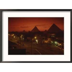  Nazlet el Samman, town with Giza pyramids, sunset Framed 